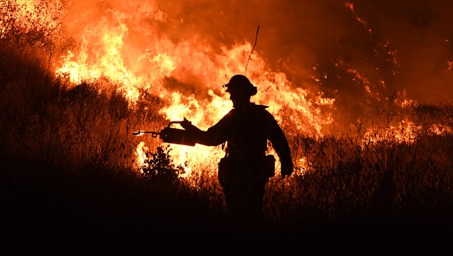 Firefighters conduct a controlled burn to defend houses against flames from the Ranch Fire, as it continues to spread towards the town of Upper Lake, Calif. on Aug. 2, 2018.