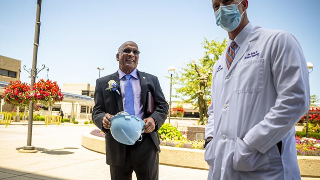 Dr. Babu Prasad, center, retired anesthesiologist, is given a hard hat by Dr. Beau Batton, right, director of newborn services, HSHS St. John's Children's Hospital NICU, after a press conference Thursday announcing a donation from Prasad of $1 million to the HSHS St. John's Foundation for the St. John's Children's Hospital NICU project.