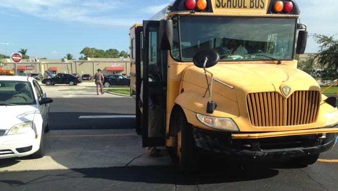 The driver of a Lee County school bus was cited after her bus crashed into a car and injured the driver Monday.