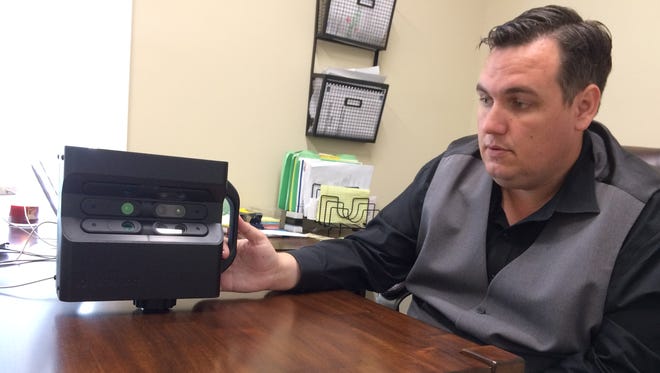 Christopher Wilson, a real estate agent with the Taber Team at Exit Realty, shows off the group's new 360-degree camera at the firm's office on Memorial Boulevard in Murfreesboro.