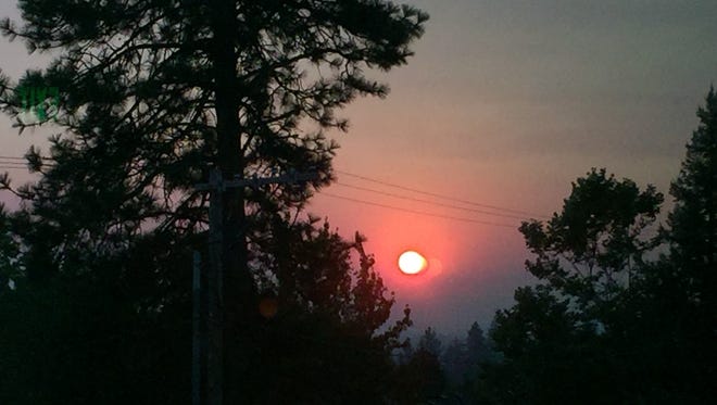 The sun took a reddish cast early Wednesday after smoke from wildfires in British Columbia moved over the area.