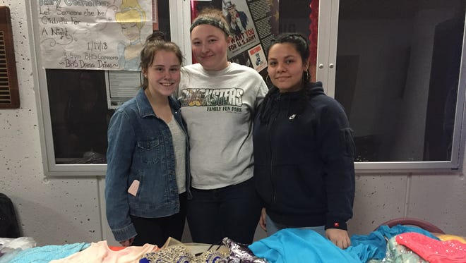 Sisters for Sisters members Nikki Shields, Gabby Brown and Jasmine Sanz stayed after school Wednesday to collect used prom dresses for those in need.