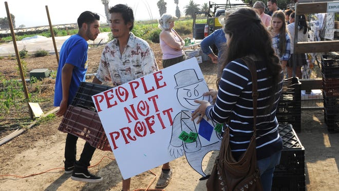People gather, some carrying signs moments before a news conference at The Abundant Table in Camarillo Thursday put on by Central Coast Alliance United for a Sustainable Economy to discuss the need for alternatives to pesticides on crops in Ventura County.