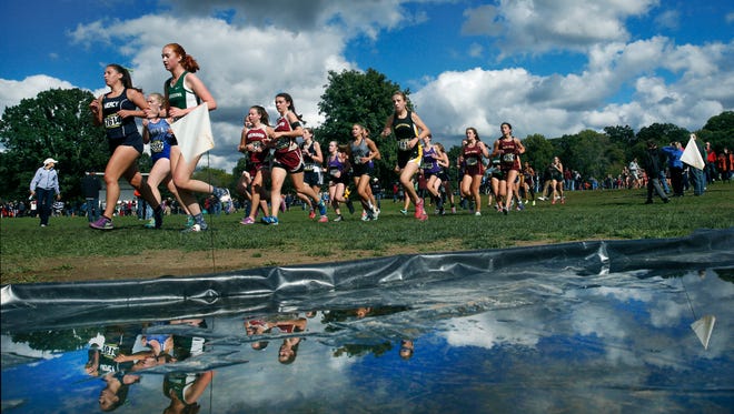 Girls Varsity B runners for medium-sized schools pass a puddle during the 53rd McQuaid Invitational at Genesee Valley Park. There were over 8,000 runners in the list of races.