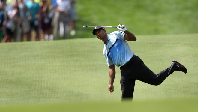 Tiger Woods reacts to his shot on 18.