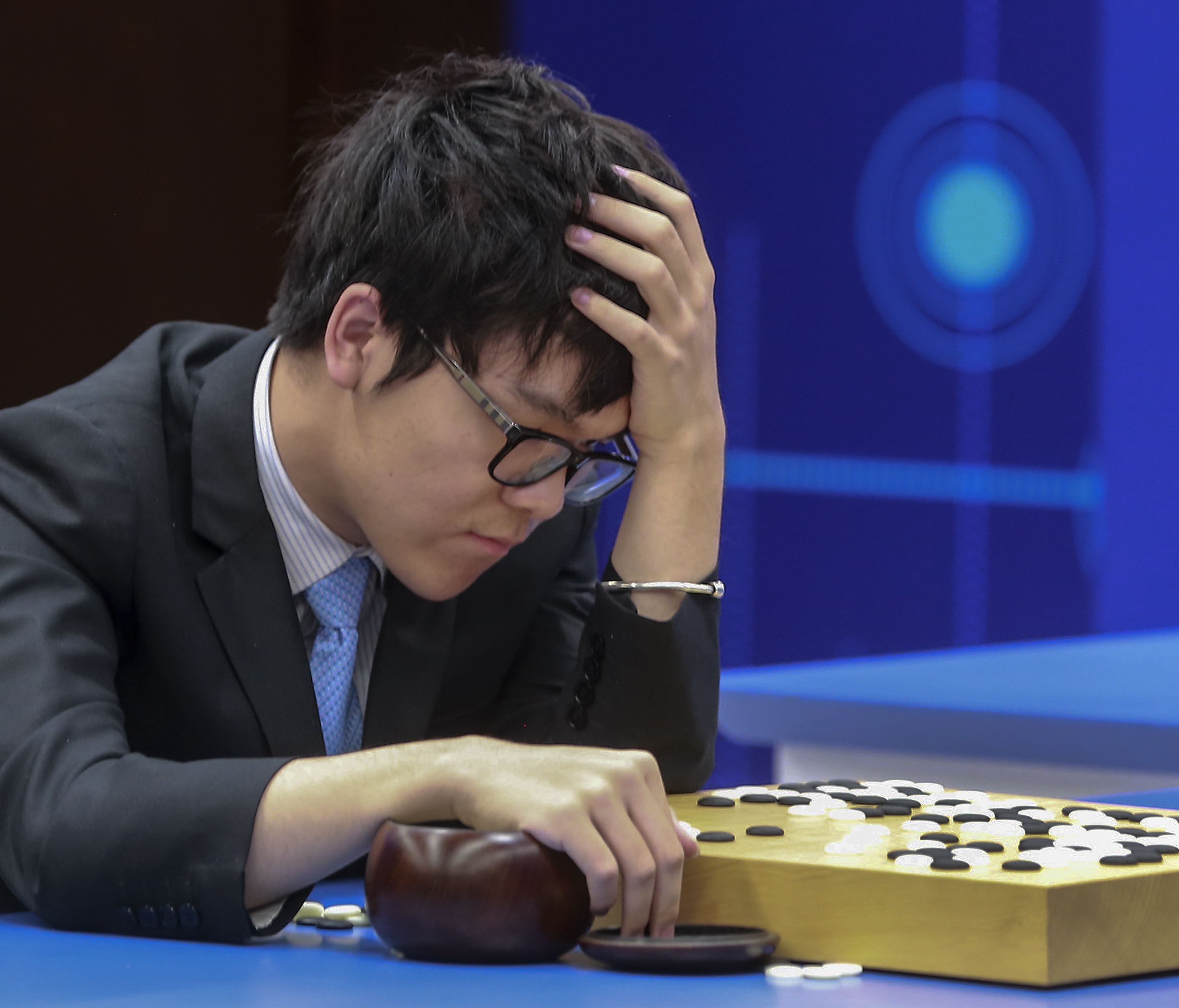 Chinese Go player Ke Jie reacts as he plays a match against Google's artificial intelligence program, AlphaGo, during the Future of Go Summit in Wuzhen in eastern China's Zhejiang Province.