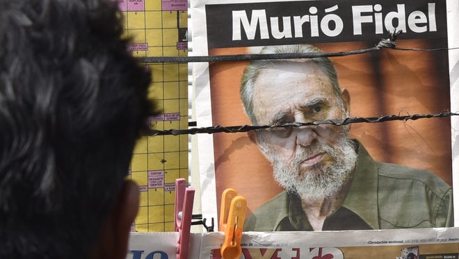 A man looks at newspaper front pages at a kiosk in La Paz, Bolivia, on Nov. 26, 2016, the morning after Cuba's revolutionary leader Fidel Castro died.