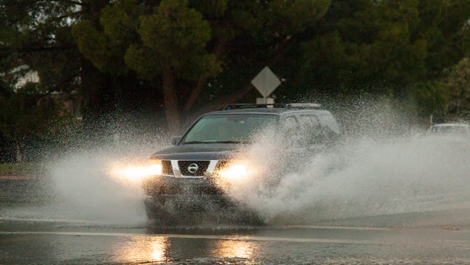 St. George drivers navigate rain runoff on Flood Street Thursday, July 12, 2018.