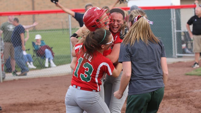 Oak Harbor's Seree Petersen (wearing helmet) is greeted by her teammates after scoring the game-tying run on a close play at the plate. The Rockets defeated Willard 2-1 in 12 innings in the sectional tournament at Oak Harbor.
