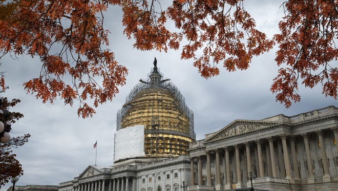 FILE - This Nov. 13, 2014, file photo shows the U.S. Capitol Dome, in Washington, surrounded by scaffolding for a long-term repair project, and framed by the last of autumn's colorful leaves.  Like a student who waited until the night before a deadline, lawmakers resuming work Monday will try to cram two years of leftover business into two weeks while avoiding a government shutdown. (AP Photo/J. Scott Applewhite, File)