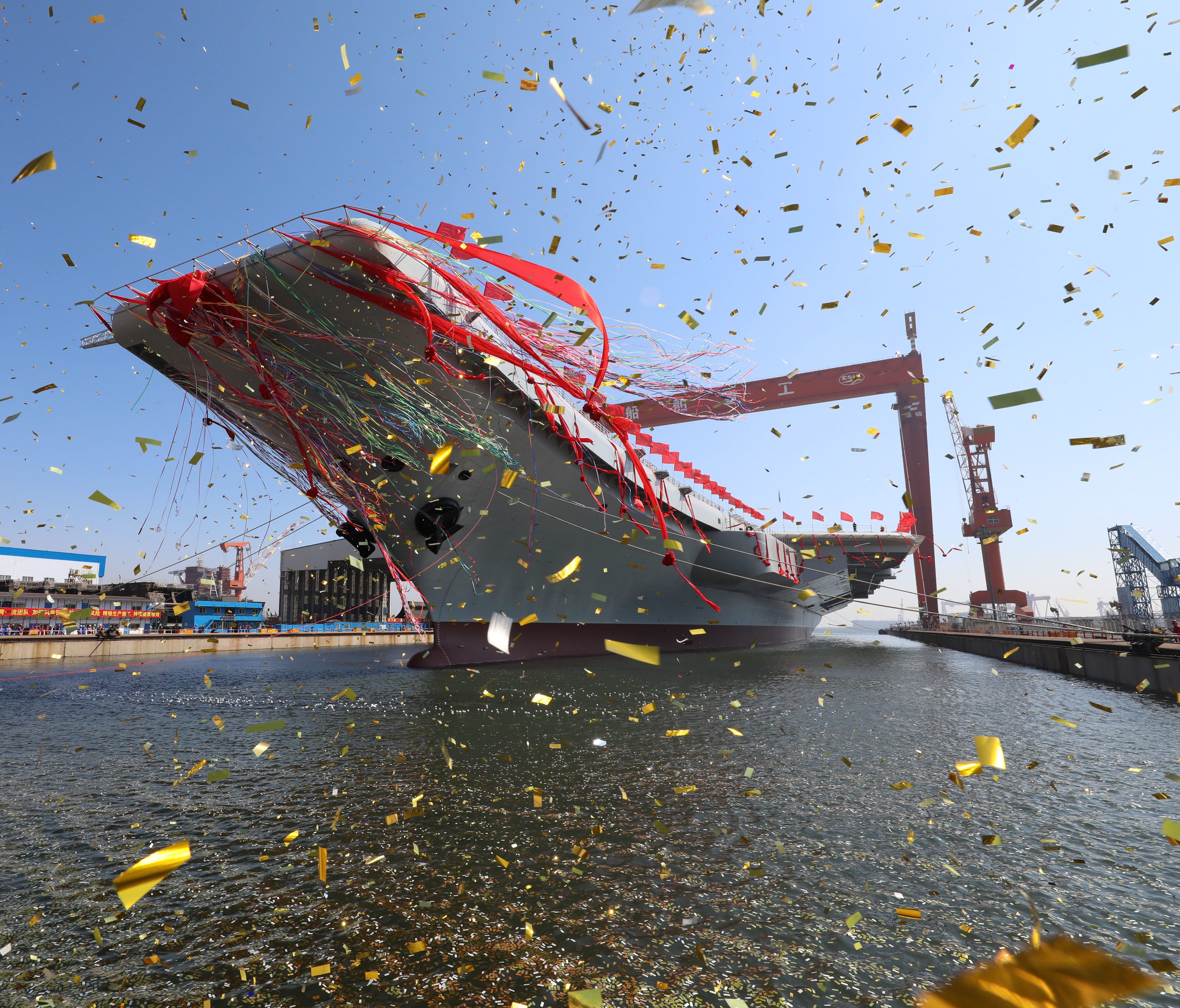 In this photo released by China's Xinhua News Agency, a newly-built aircraft carrier is transferred from dry dock into the water at a launch ceremony at a shipyard in Dalian in northeastern China's Liaoning Province, Wednesday, April 26, 2017. China 