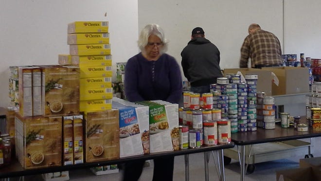 Volunteers sort donated food distributed to 113 area senior citizens through the Christmas Blessing project operated by Livingston County Catholic Charities.