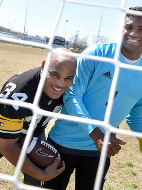 Former NFL running back Leroy Thompson and son, West High School goalkeeper Dezmond Thompson on the West High School football and soccer field on Wednesday, March 25, 2015.