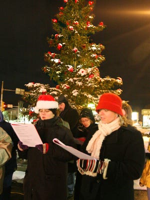 Petra Eccarius Brylow (L) and Martha Albers sing at a past Thiensville Christmas Tree Lighting event. This year's event is set for Friday, Dec. 1.