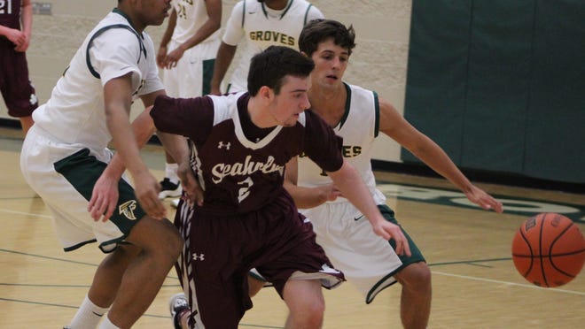 Seaholm point guard Justin Rothschild (front) is pinned in by Groves defenders Jonnie Reece (left) and Grant Gilbert during Tuesday’s crosstown rivalry game.