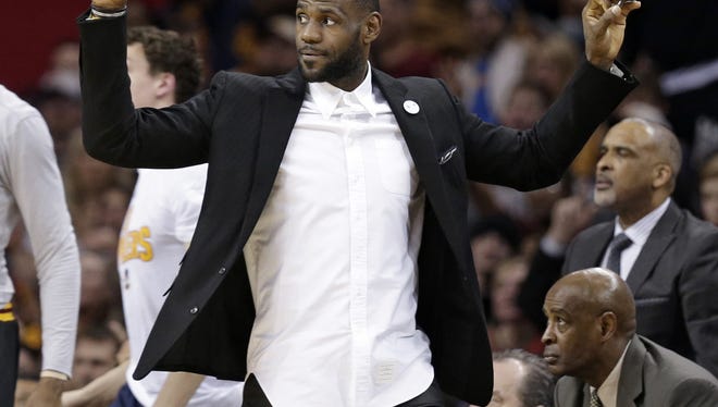 Cleveland Cavaliers' LeBron James reacts from the bench in the first half of an NBA basketball game between the Houston Rockets and the Cavaliers, Tuesday, March 29, 2016, in Cleveland. (AP Photo/Tony Dejak)