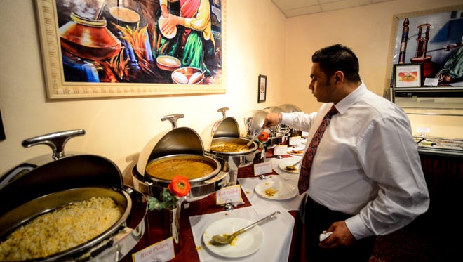 Endicott resident Billa Singh, manager of Royal Indian Bar & Grill, examines the buffet during the lunch hour.