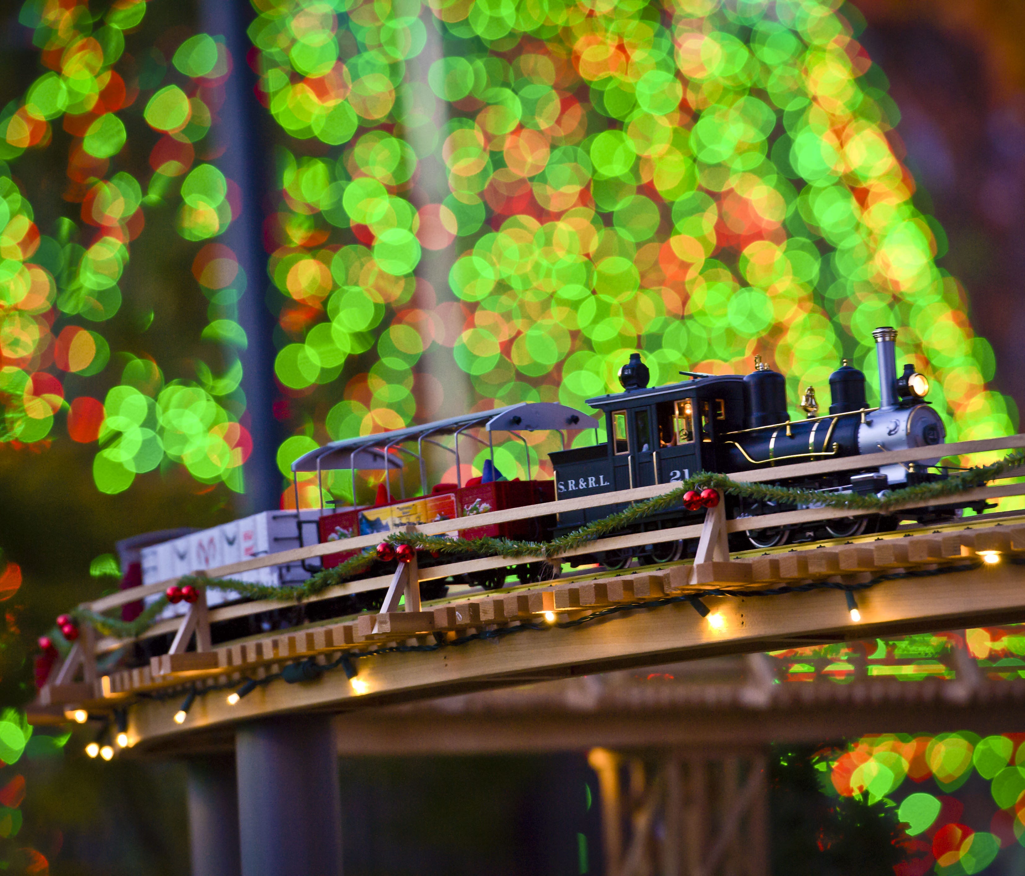 A train passes over one of five bridges that are part of the Holiday Model Train Show at the Atlanta Botanical Garden.