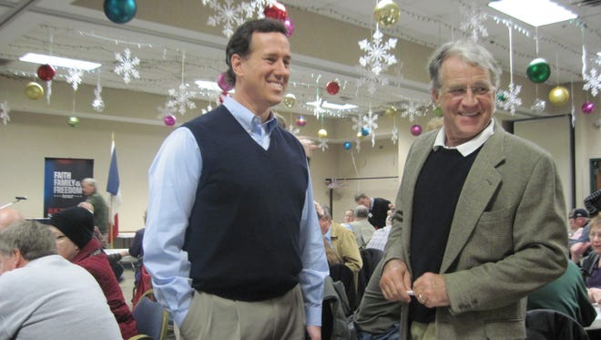 A smiling Rick Santorum wore a sweater vest  as he campaign in Davenport just prior to the 2012 Iowa caucuses. He was standing next to John Searles of Davenport.