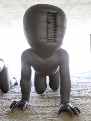 Large sculptures by artist David Černý, "Babies." are on display in downtown Palm Springs.