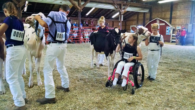 Caroline Powers stands in line with her March calf and waits for the junior-champion announcement during the junior dairy show at the Dodge County Fair.