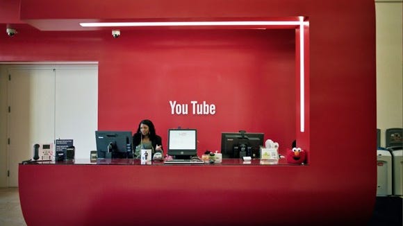 A bright red office lobby with the YouTube logo in white on the wall.