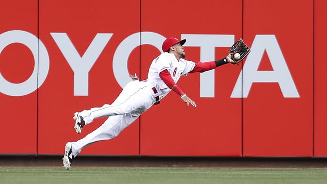 Reds center fielder Billy Hamilton dives for a ball off the bat of Milwaukee's Carlos Gomez.
