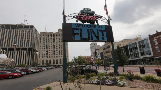 A video sign flashes a Welcome to Flint sign off of Saginaw Street in downtown Flint in this 2013 photo.