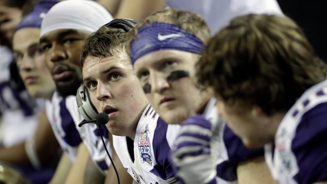 Washington quarterback Jake Browning (with headset) and offensive teammates watch seemingly in disbelief during the second half of the Peach Bowl.