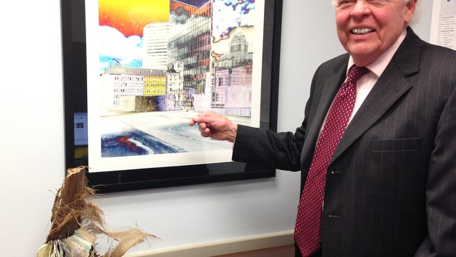 
Vice Mayor David Mann shows off some of his office’s artwork from local artists, including Reflections, by Phil Compton (hanging) and The Story of Ida Martin, by Judith Serling-Strum (sitting on table).
