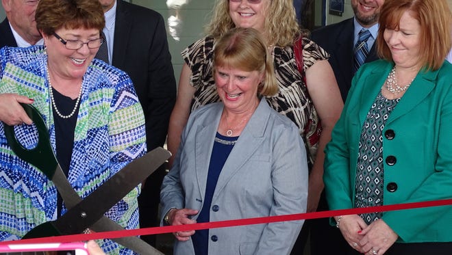 Lancaster School Board members, from left, Kathy Kittridge, Lise Ricketts, and Amy Eyman cut the ribbon for the new Mt. Pleasant Elementary School on Broad Street Thursday.