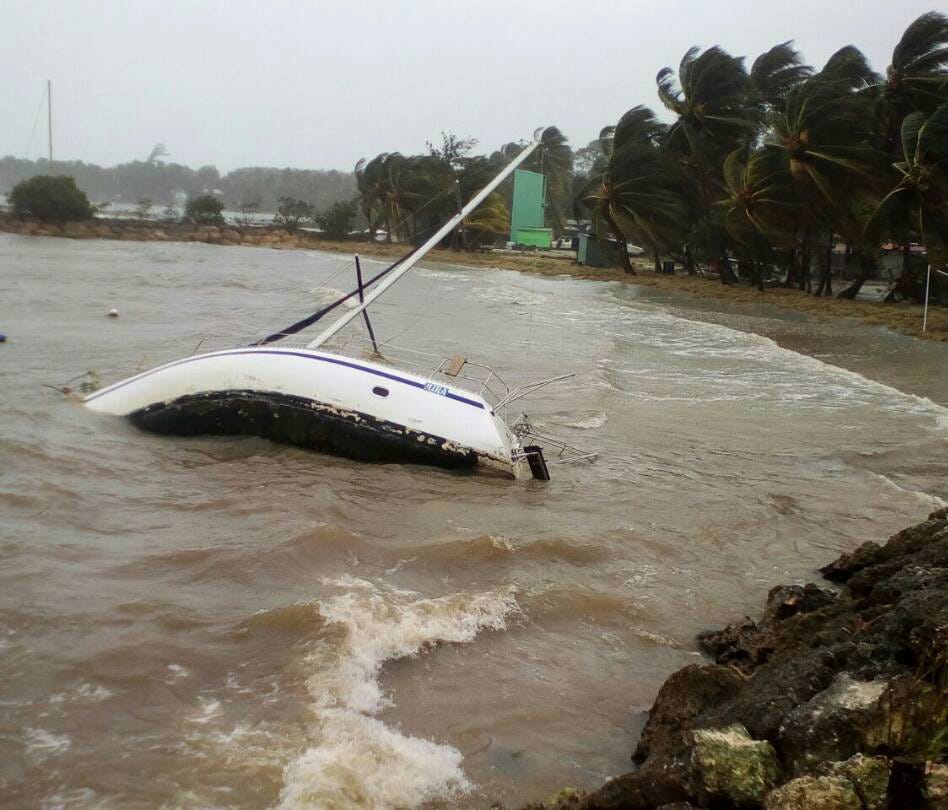 A boat lays on its side off the shore of Sainte-Anne on the French Caribbean island of Guadeloupe after Hurricane Maria passed.