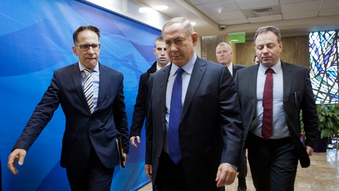 Israeli Prime Minister Benjamin Netanyahu, center, arrives for a weekly cabinet meeting in Jerusalem, Sunday, Dec. 25, 2016.
