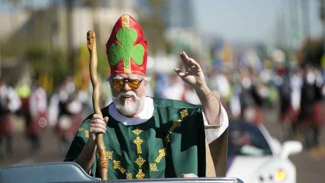 Dressed as St. Patrick, Don McMasters waves to the crowd during the Phoenix St. Patrick's Day Parade along Third Street on March 11, 2017.
