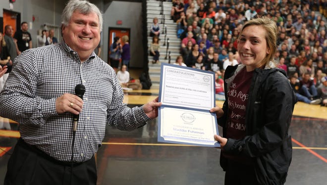 Statesman Journal Executive Editor Michael Davis presents Maddie Fuhrman with an award certificate and invitiation to the Mid-Valley Sports Awards during an assembly on Friday, April 15, 2016, at Silverton High School.