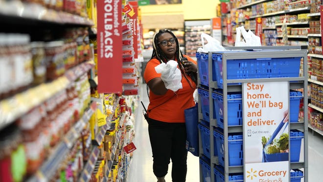In this Nov. 9, 2018, file photo, Walmart associate Alicia Carter fulfills online grocery orders at a Walmart Supercenter in Houston. More than 40 million individuals receive food stamps in the U.S., according to the USDA.