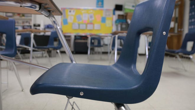 An empty chair is among several inside a classroom at South Lenoir High School Monday, March 16.