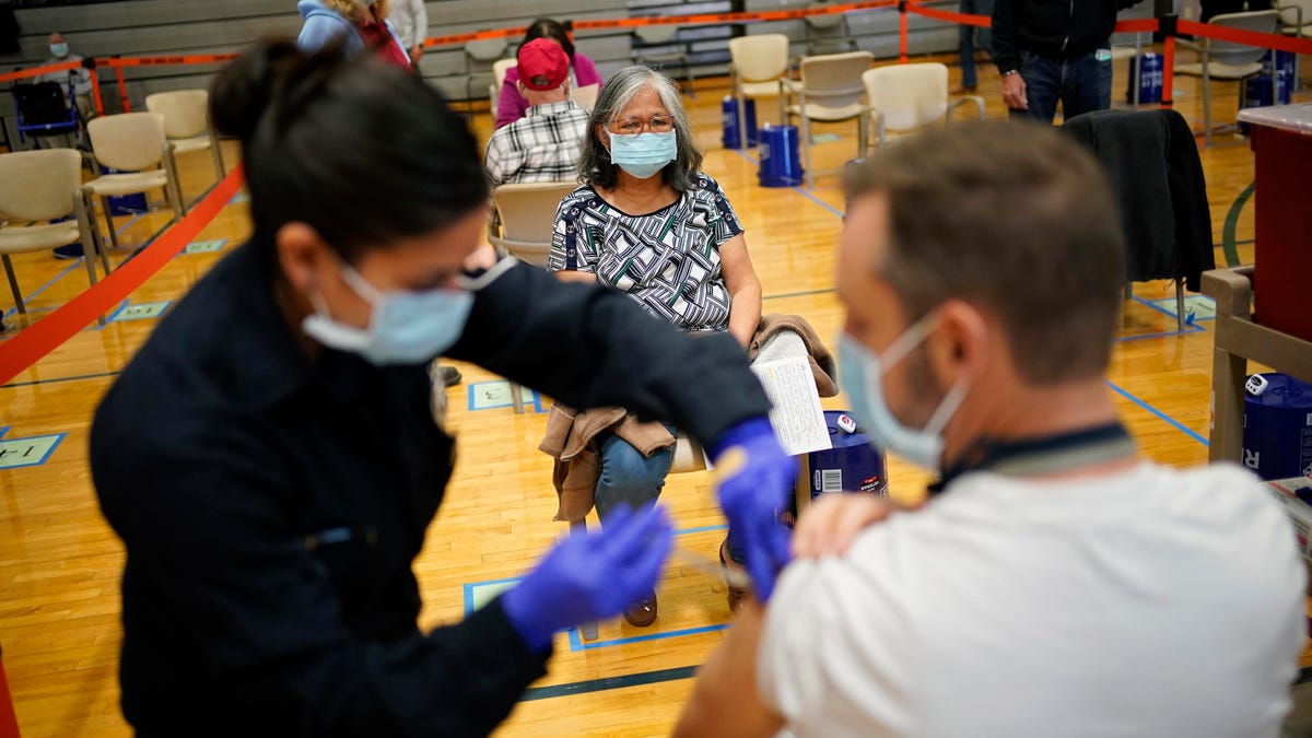 People get COVID-19 shots at a vaccination site in Las Vegas.