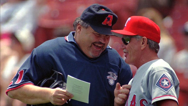 Home plate umpire Ken Kaiser, left, and Texas Rangers manager Johnny Oates go over the lineup before the game against the Kansas City Royals on June 8, 1997, in Kansas City, Missouri.