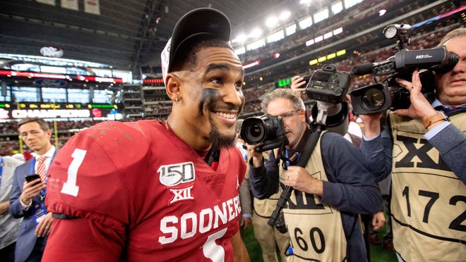 Oklahoma quarterback Jalen Hurts (1) smiles after putting on his conference championship hat after Oklahoma's 30-23 overtime victory over Baylor in an NCAA college football game for the Big 12 Conference championship, Saturday, Dec. 7, 2019, in Arlington, Texas. (AP Photo/Jeffrey McWhorter)