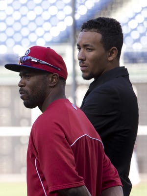 The Phillies’ Jimmy Rollins watches batting practice with prospect J.P. Crawford Friday.