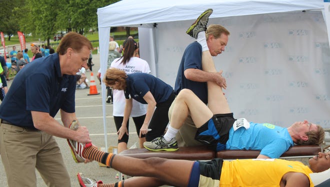 Doctors stretching runners.