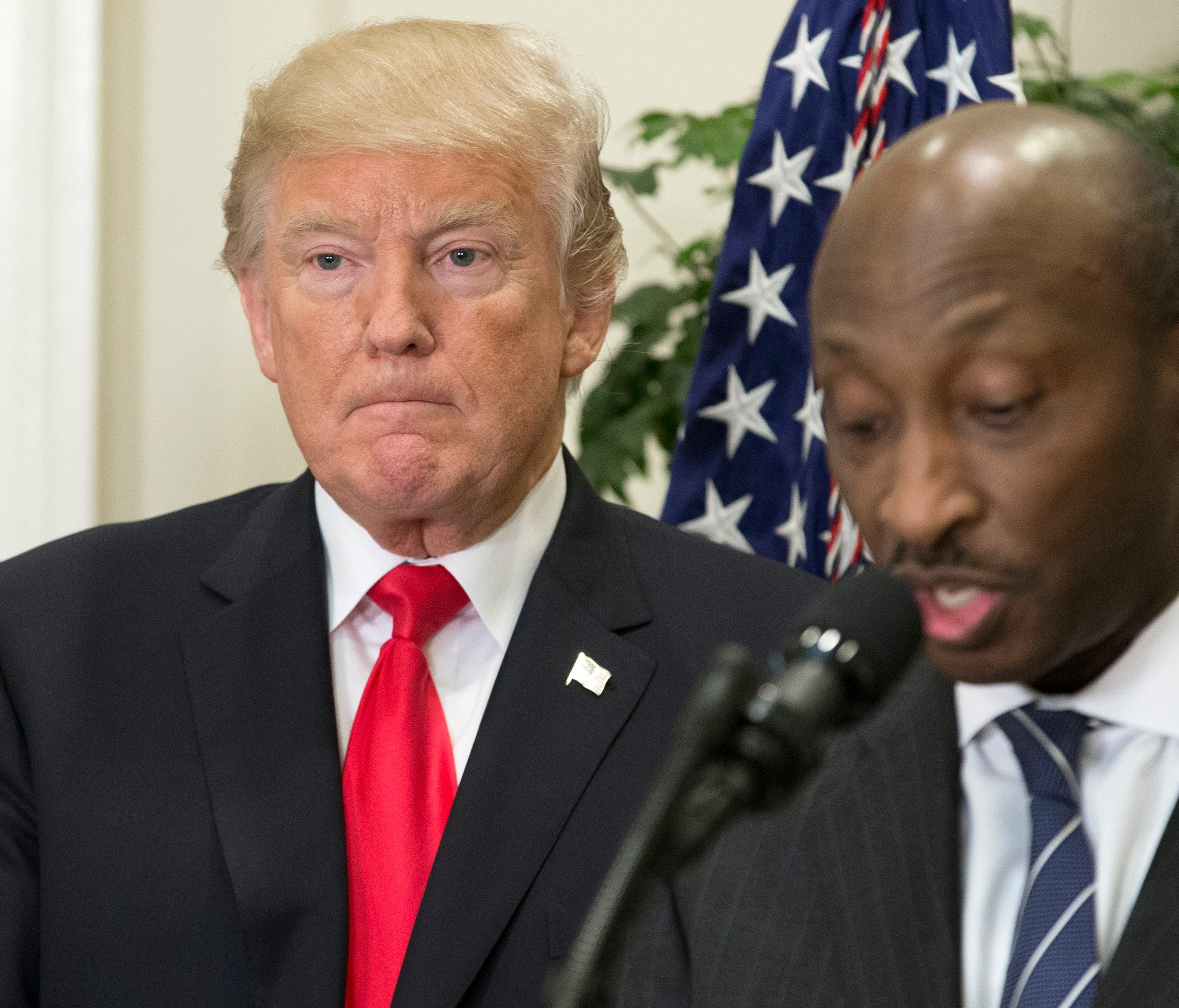 File photo shows President Trump listening as Merck CEO Ken Frazier speaks during the July 2017 White House announcement of a pharmaceutical glass packaging initiative.
