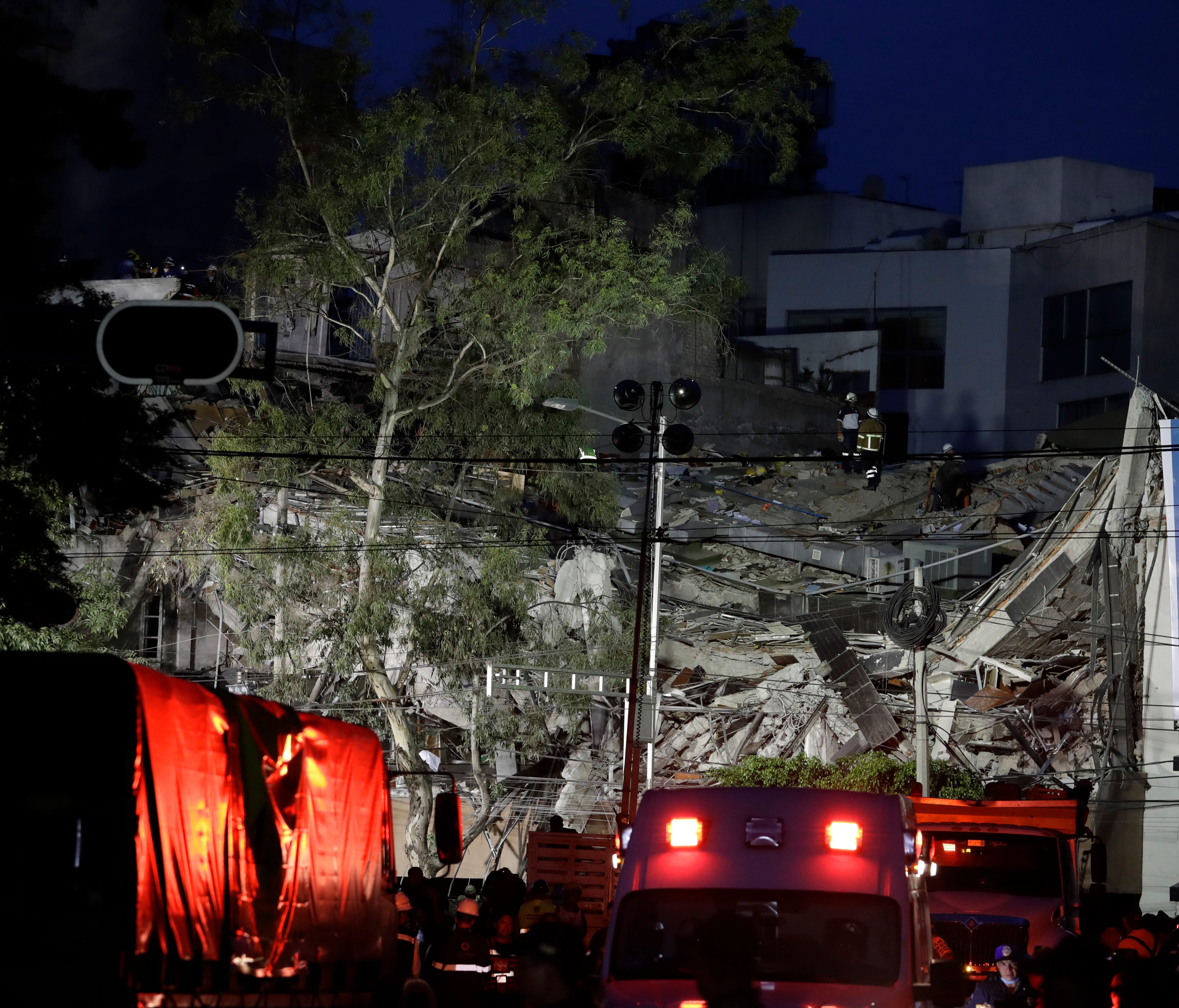 Rescue workers continue to search through rubble in a collapsed building in the Roma neighborhood, in Mexico City, as night falls on Tuesday.