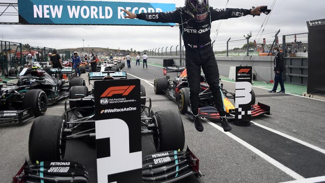 Lewis Hamilton jumps out of his car after his record-breaking 92nd win at the Formula One Portuguese Grand Prix on Sunday. "I could only ever have dreamed of being where I am today," Hamilton said.