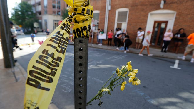 Police tape and flowers mark the site Aug. 13, 2017, where a car plowed into a crowd of people protesting a white nationalist rally in Charlottesville, Virginia.