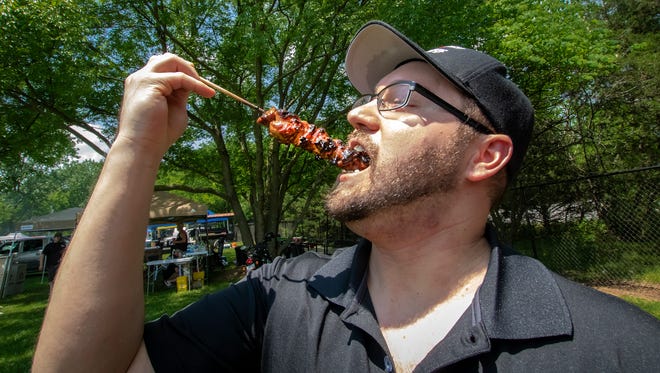 Kris Aubichar samples some of the meat he was preparing at the Murfreesboro Breakfast Rotary Club's annual Backyard BBQ Festival, held Saturday at Cannonsburgh Village.