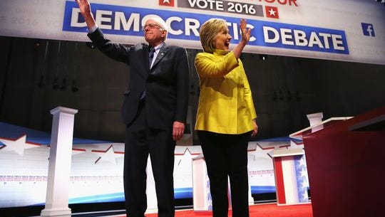 Bernie Sanders and Hillary Clinton walk out on stage for the PBS NewsHour Democratic debate.