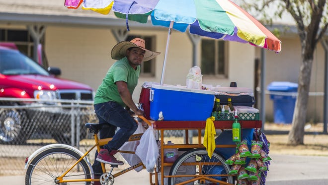 Ernesto Garcia rides through Maryvale selling sells snacks June 25, 2016.