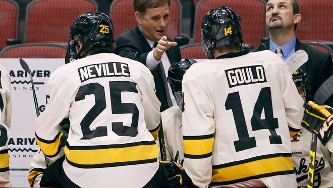 Michigan Tech coach Mel Pearson, center, talks with Michael Neville (25) and Malcollm Gould (14) during the first period against Connecticut at the Desert Hockey Classic tournament on Jan. 8, 2016, in Glendale, Ariz.